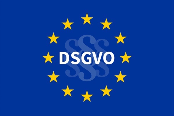 Schriftzug DSGVO auf blauem Grund mit zwölf goldenen EU-Sternen und Paragraphenzeichen im Hintergrund